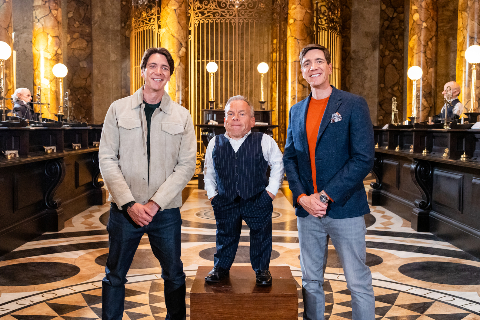 Hosts James Phelps and Oliver Phelps with guest judge Warwick Davis