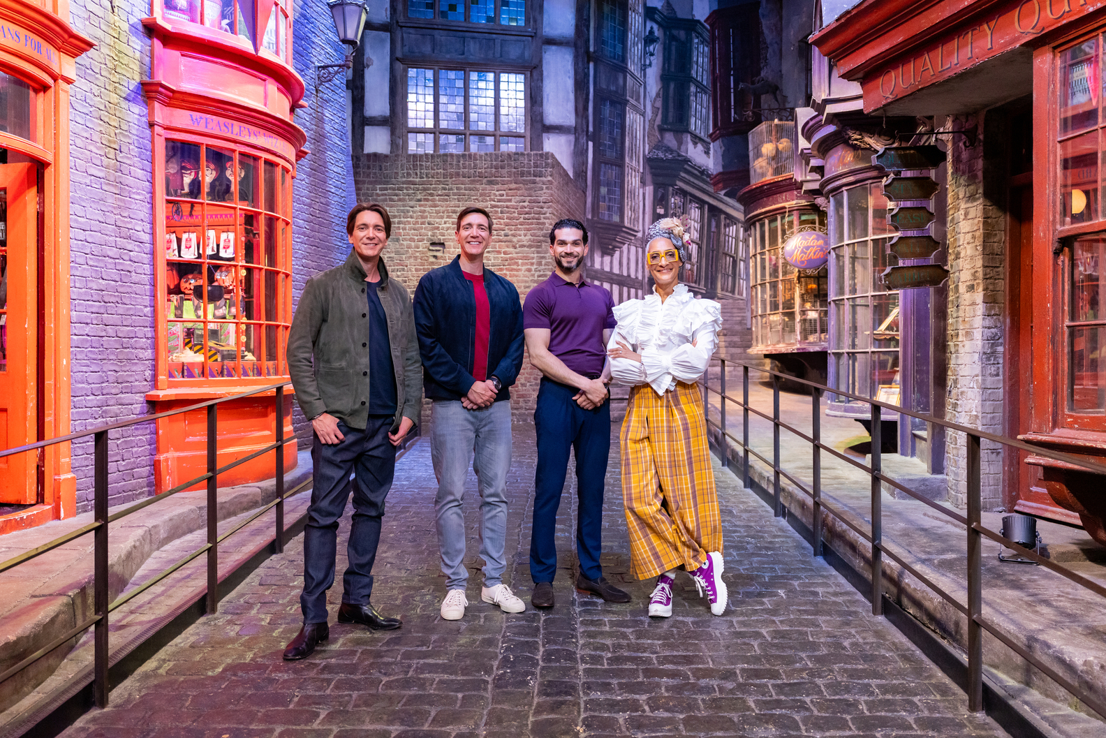 Hosts James and Oliver Phelps with Judges Carla Hall and Jozef Youssef pose in Diagon Alley Food Network Harry Potter Wizards of Baking