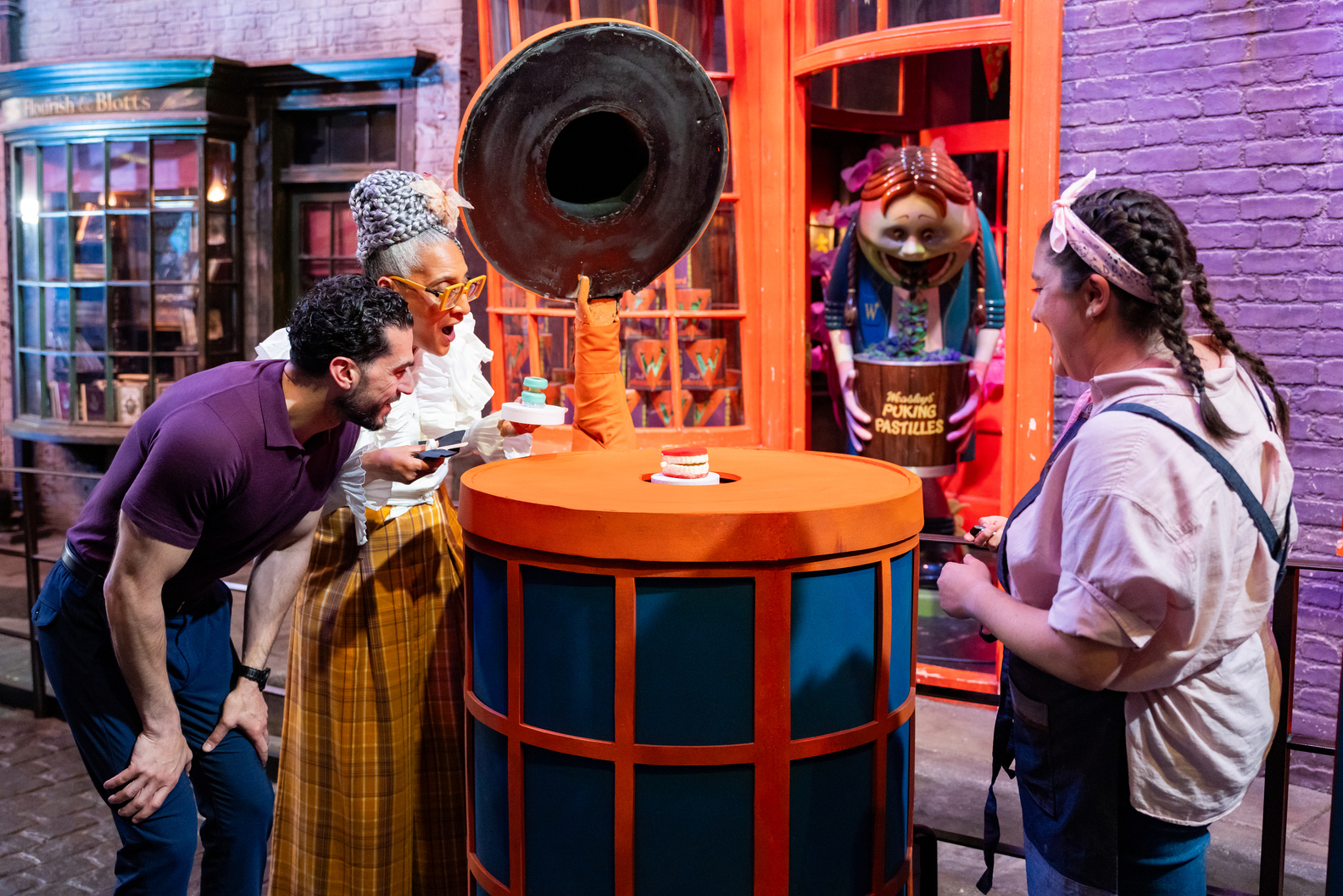 Judges Carla Hall and Jozef Youssef inspect a competitors creation in Diagon Alley Food Network Harry Potter Wizards of Baking