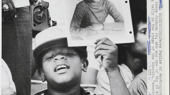 Child holding photo of his cousin, victim Aaron Jackson, on steps of Lincoln Memorial in protest (5/25/81)