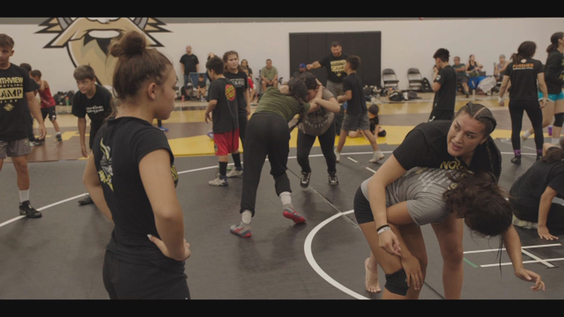 Tatiana Suarez (right) teaching Lexi Garza (left) and the other female wrestlers at Northview High School
